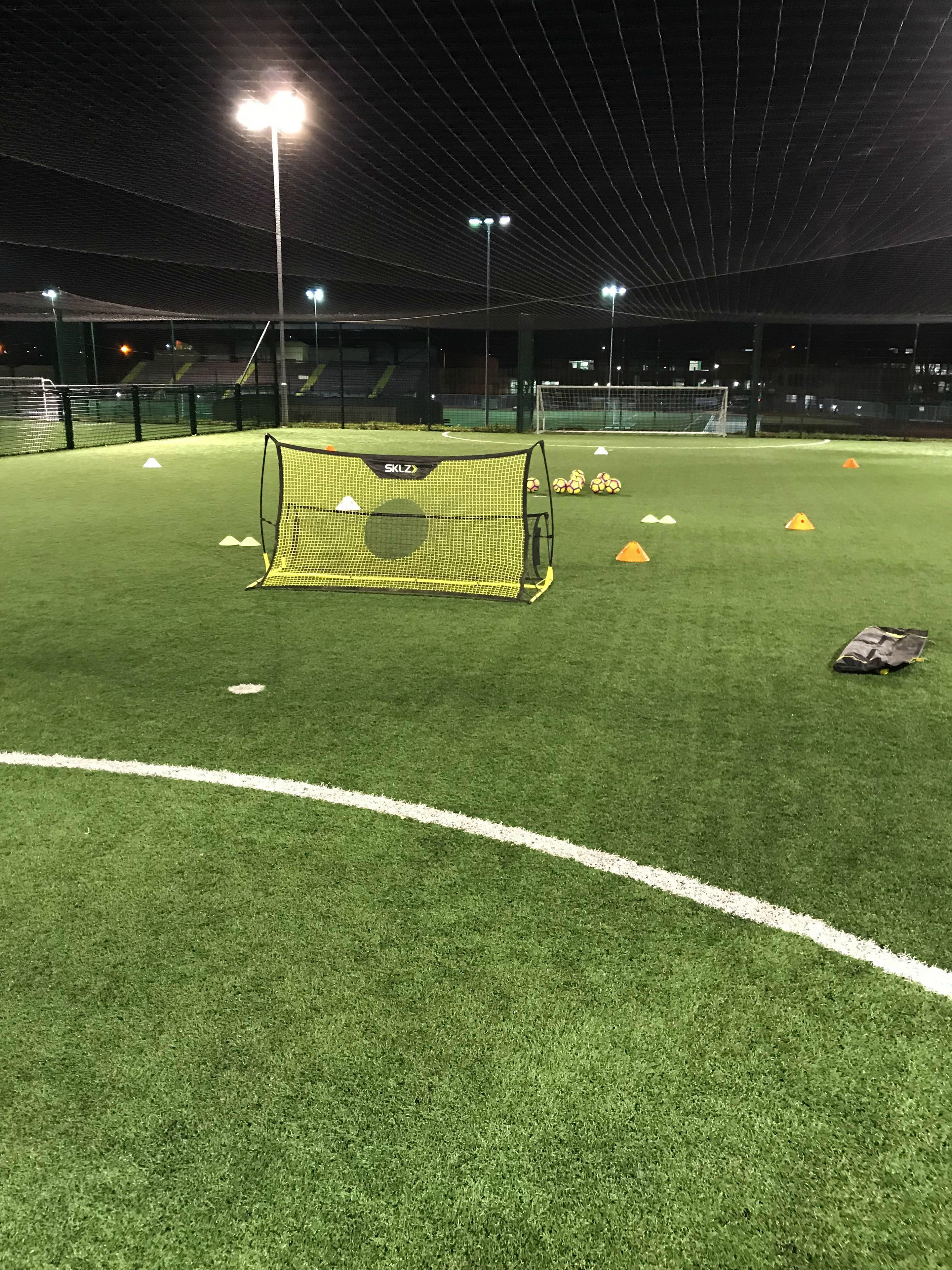 Training venue with football rebounder and cones laid out